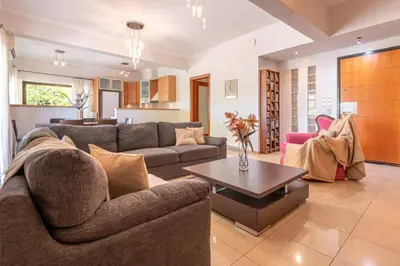 a living room with a couch and a table at Phaedrus Living Moschato City Flat in Piraeus