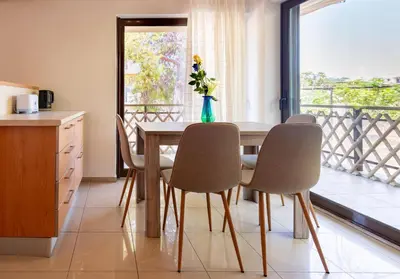 a dining room with a table and chairs and a balcony at Phaedrus Living Moschato City Flat in Piraeus