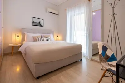 a white bedroom with a large bed and a window at Phaedrus Living Moschato City Flat in Piraeus