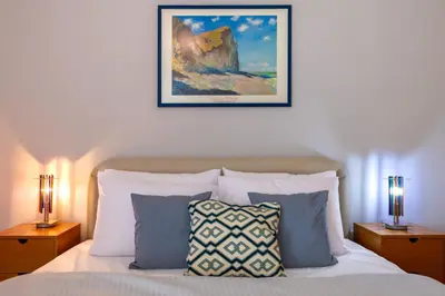 a bedroom with a bed with two lamps and a picture on the wall at Phaedrus Living Moschato City Flat in Piraeus