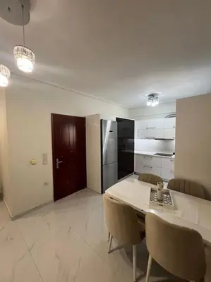 a kitchen with a table and chairs and a refrigerator at Modern and comfortable apartment 5km from center in Athens