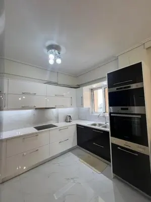a kitchen with white cabinets and black appliances at Modern and comfortable apartment 5km from center in Athens