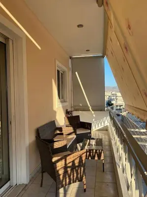 a balcony with chairs and a table on a building at Modern and comfortable apartment 5km from center in Athens