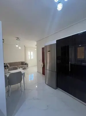 a kitchen and dining room with a stainless steel refrigerator at Modern and comfortable apartment 5km from center in Athens