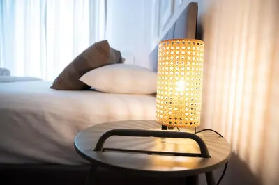 a lamp sitting on a table next to a bed at Urban Comfort 2 bdrm next to Metro in Athens
