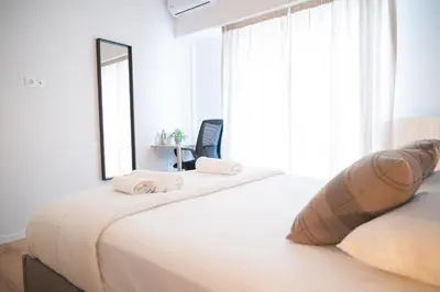 a bedroom with a large bed with a large window at Urban Comfort 2 bdrm next to Metro in Athens