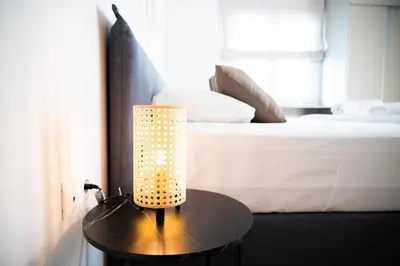 a lamp on a table next to a bed at Urban Comfort 2 bdrm next to Metro in Athens