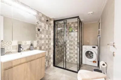a bathroom with a sink and a washing machine at Urban Comfort 2 bdrm next to Metro in Athens