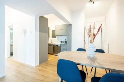 a dining room with a wooden table and blue chairs at Urban Comfort 2 bdrm next to Metro in Athens