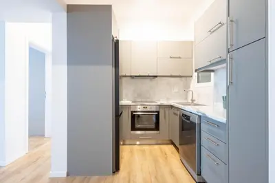 a kitchen with white cabinets and stainless steel appliances at Urban Comfort 2 bdrm next to Metro in Athens