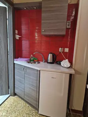 a small kitchen with red walls and a counter top at 4 Seasons Suites Paradise Near Airport And Beach 2 in Markopoulo