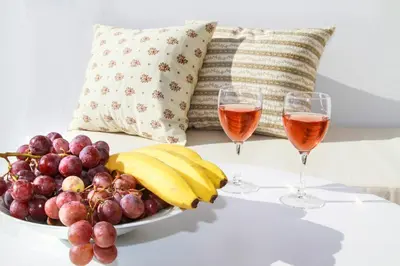 two glasses of wine and a bowl of fruit at 4 Seasons Suites Paradise Near Airport And Beach 2 in Markopoulo