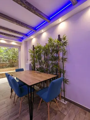 a dining room with a wooden table and blue chairs at Island 3siblings in Athens