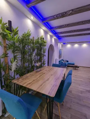 a conference room with a wooden table and blue chairs at Island 3siblings in Athens