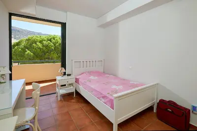 a bedroom with a bed and a desk and a window at soft blue apartment near seaside in Porto Rafti