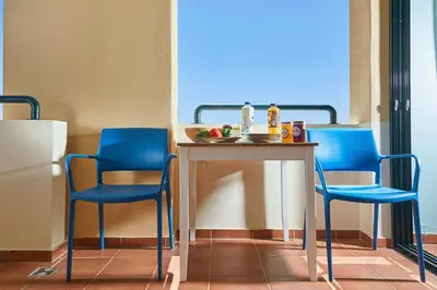 two blue chairs and a table in a room at soft blue apartment near seaside in Porto Rafti