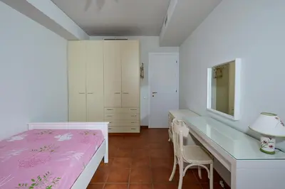 a bedroom with a bed and a desk with a mirror at soft blue apartment near seaside in Porto Rafti