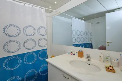 a bathroom with a sink and a mirror at soft blue apartment near seaside in Porto Rafti