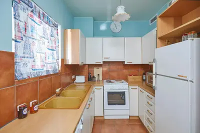 a kitchen with white cabinets and a white refrigerator at soft blue apartment near seaside in Porto Rafti