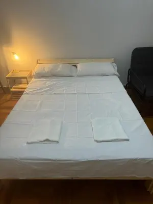 a large white bed with two towels on it at Spartan Residence in Athens