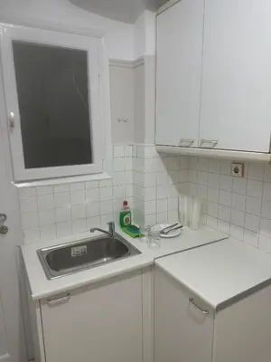 a white kitchen with a sink and a window at Spartan Residence in Athens