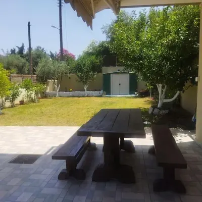 a picnic table with two benches on a patio at Aurora Studio Lagonissi in Lagonissi