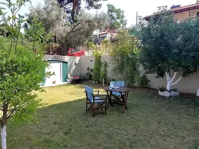 a table and chairs in the yard of a backyard at Aurora Studio Lagonissi in Lagonissi