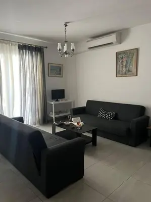 a living room with a couch and a table at Aurora Studio Lagonissi in Lagonissi
