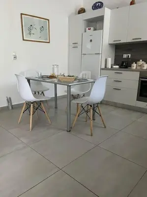 a kitchen with a table and two white chairs at Aurora Studio Lagonissi in Lagonissi
