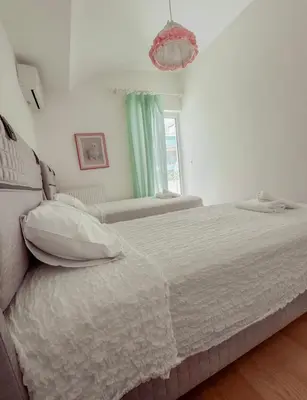 a bedroom with two beds and a chandelier at Aegean Pearl in Porto Rafti