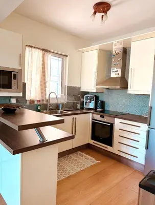 a kitchen with white cabinets and a counter top at Aegean Pearl in Porto Rafti