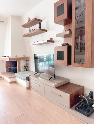 a living room with a fish tank on a cabinet at Aegean Pearl in Porto Rafti