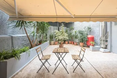 a patio with a table and chairs and plants at Athens4U Pagrati 1Gbps Near Metro in Athens