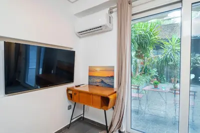 a room with a tv and a desk and a window at Athens4U Pagrati 1Gbps Near Metro in Athens