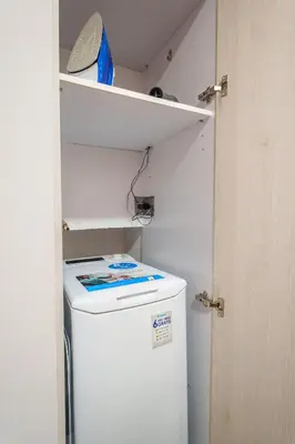 a small white refrigerator in a kitchen with a shelf at Athens4U Pagrati 1Gbps Near Metro in Athens