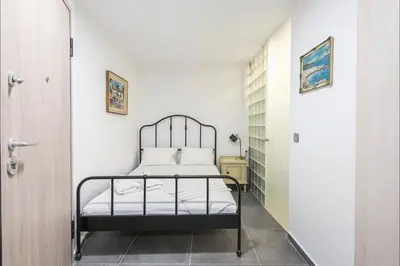 a bedroom with a metal bed in a white room at Athens4U Pagrati 1Gbps Near Metro in Athens