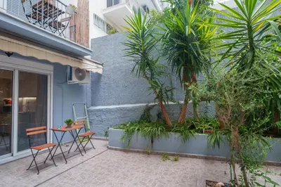 a patio with a table and chairs next to a building at Athens4U Pagrati 1Gbps Near Metro in Athens