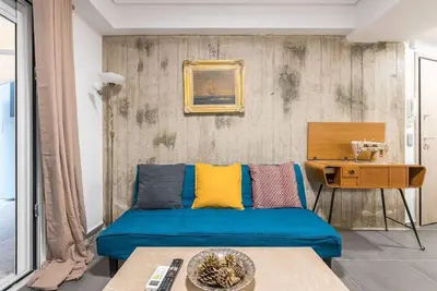 a living room with a blue couch and a table at Athens4U Pagrati 1Gbps Near Metro in Athens