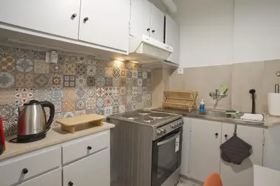 a kitchen with white cabinets and a stove top oven at Hill House Lycabettus Stylish near Athens Center in Athens