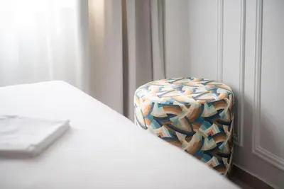 a chair sitting next to a bed in a room at Stylish Comfort Apt in Athens Centre in Athens
