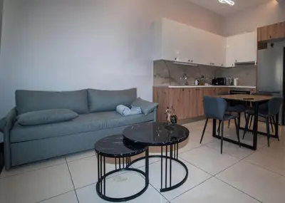 a living room with a couch and a table and a kitchen at Sia's Retreat 1 Modern Apt Athens Riviera in Athens
