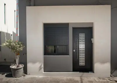 a building with a black door and a window at Sia's Retreat 1 Modern Apt Athens Riviera in Athens