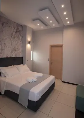 a bedroom with a large bed with white sheets at Sia's Retreat 1 Modern Apt Athens Riviera in Athens