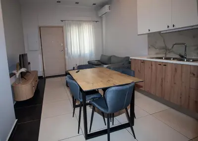 a kitchen with a wooden table and blue chairs at Sia's Retreat 1 Modern Apt Athens Riviera in Athens