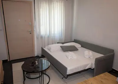 a bed in a small room with a glass table at Sia's Retreat 1 Modern Apt Athens Riviera in Athens