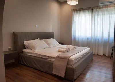 a bed in a room with a large window at Sia's Retreat 2 Modern Apt Athens Riviera in Athens