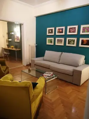 a living room with a couch and a blue wall at Unique 3 BDRM apartment, 5 min walk from Acropolis in Athens