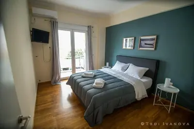 a bedroom with a large bed with a blue wall at Unique 3 BDRM apartment, 5 min walk from Acropolis in Athens