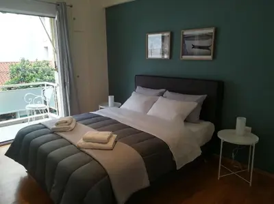 a bedroom with a large bed with a green wall at Unique 3 BDRM apartment, 5 min walk from Acropolis in Athens
