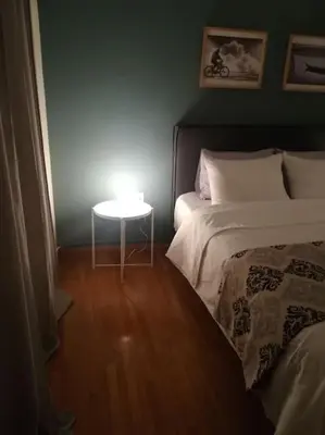 a bedroom with a bed and a table with a light at Unique 3 BDRM apartment, 5 min walk from Acropolis in Athens